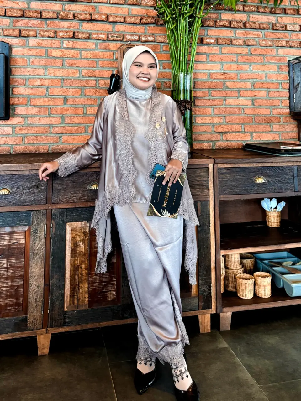 Putri memegang buku MC sambil tersenyum